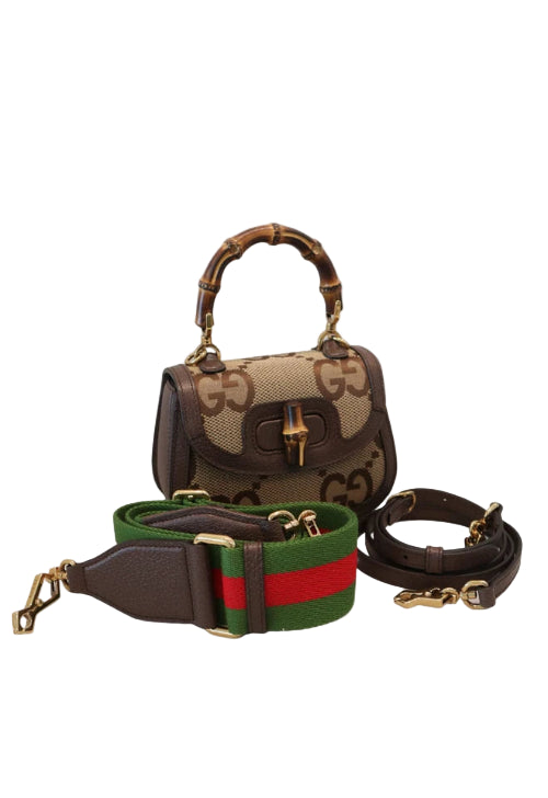 Designer handbag with matching strap on a light gray background