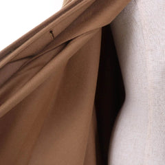 Close-up of brown fabric with a visible seam on a white background