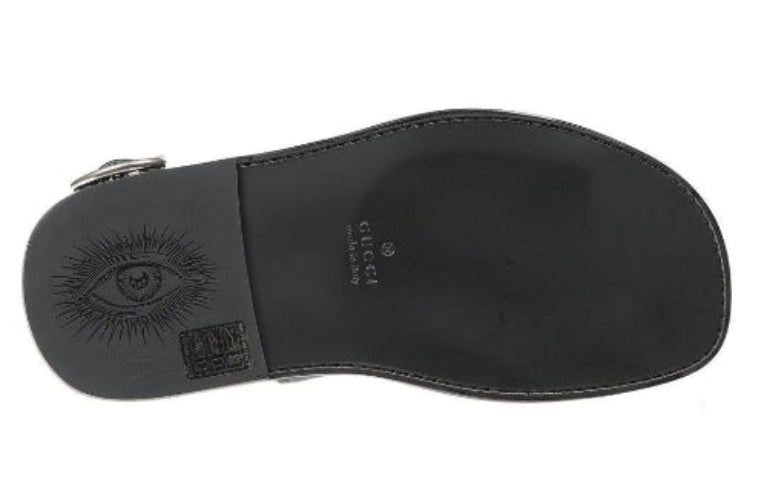 Black sandal sole with Gucci logo and eye emblem on a white background