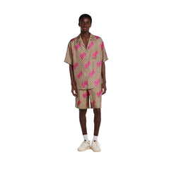 Person wearing a patterned dress standing against a plain background