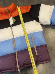 Multicolored puffer jacket with a measuring tape on a gray surface