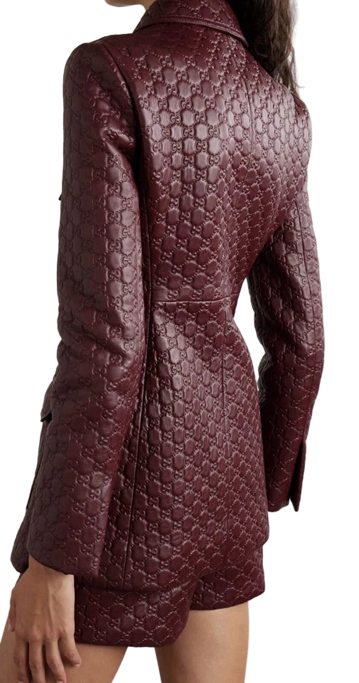 Quilted burgundy jacket worn by a person on a light gray background