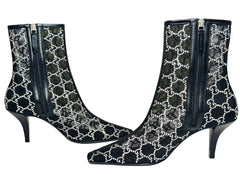 Black high-heeled boots with white pattern on a Gucci box