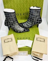 Gucci black patterned ankle boots with branded box and packaging on a white background