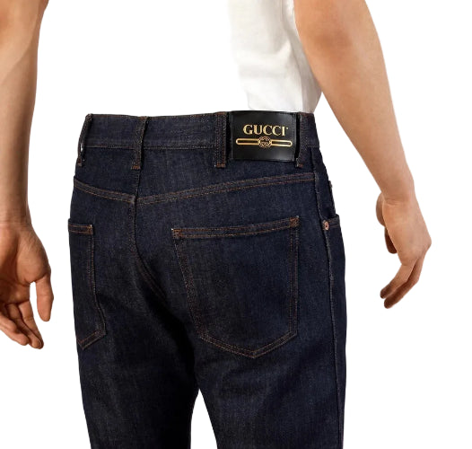 Close-up of a person wearing dark blue denim jeans with a black waistband and a visible Levi's brand patch.
