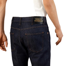Close-up of a person wearing dark blue denim jeans with a black waistband and a visible Levi's brand patch.