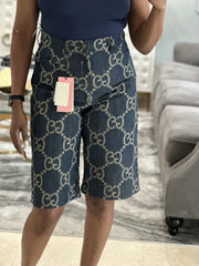 Person wearing navy shorts with a pattern, standing indoors.
