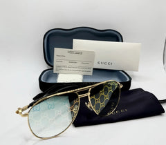 Gold-framed sunglasses with Gucci logo on a white background