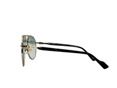 Sunglasses with gold frame and black arms on a light gray background