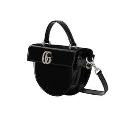 Black handbag with a brand logo on a light gray background