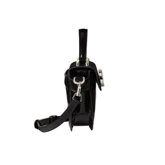 Black handbag with a strap on a light gray background