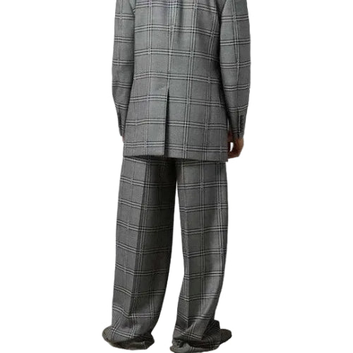 Person wearing a gray plaid suit against a plain background
