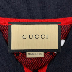 Gucci label on a red and navy fabric background