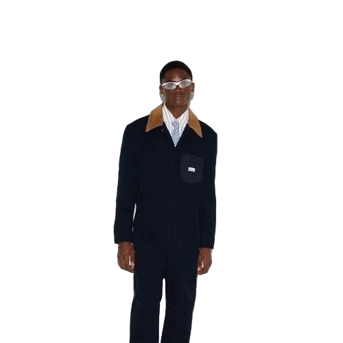 Person wearing a dark suit with a light shirt and sunglasses on a white background