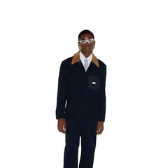 Person wearing a dark suit with a light shirt and sunglasses on a white background