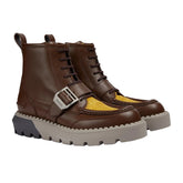 Brown leather boots with a yellow sole on a light gray background
