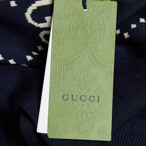 Green Gucci tag on a dark fabric background