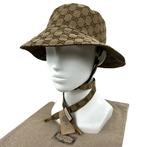 Beige bucket hat with Gucci logo on a mannequin head against a white background