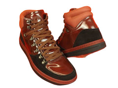 Brown high-top sneakers with black soles on an orange background