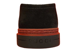 Black Gucci bottle stopper on an orange background