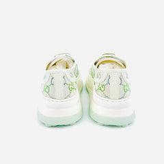 A pair of Gucci low-top sneakers shown from the back, featuring a white canvas upper with the signature green GG monogram pattern and thick white platform soles with a light mint green tint.