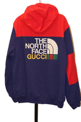 Red and blue hoodie with 'The North Face' and 'Gucci' logos on a white background