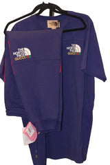 Purple t-shirt with 'The North Face' and 'Gucci' logos on a hanger against a white wall.