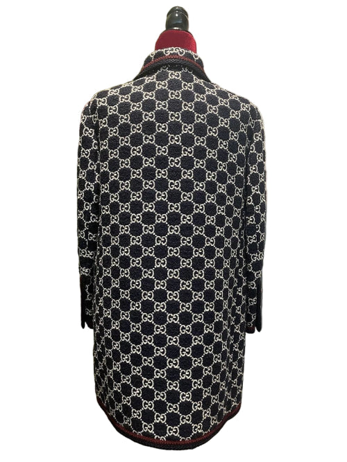 Black and white patterned coat on a mannequin with a red interior lining against a white background