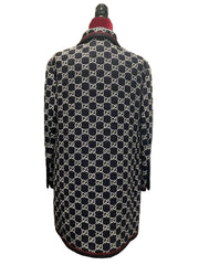 Black and white patterned coat on a mannequin with a red interior lining against a white background