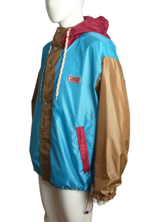 Multicolored jacket with blue, brown, and red sections on a mannequin against a white background