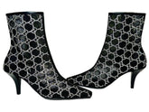 Black high-heeled boots with white pattern on a Gucci branded box.