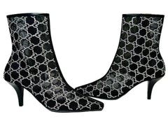 Black high-heeled boots with white pattern on a Gucci branded box.