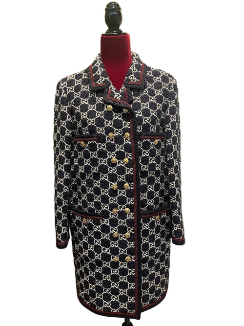 Patterned coat on a mannequin against a white door and green wall.