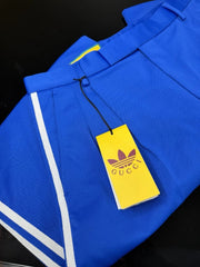 Blue Adidas sports jacket with white stripes on a plain background