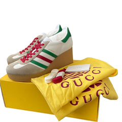 Gucci Sabaia platform sneakers in beige suede and white leather with green and red stripes, pink laces, shown with a yellow Gucci dust bag and yellow box on a white background.