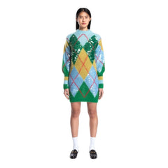 Woman wearing a colorful argyle patterned sweater dress on a white background