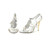 Clear high-heeled shoes with silver embellishments on a white background
