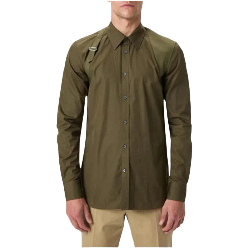 A man wearing an olive green long-sleeve button-up shirt with a collar and a small chest pocket, paired with khaki pants, against a light gray background.