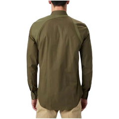 A man viewed from the back wearing a long-sleeve olive green shirt with contrasting shoulder panels and beige pants, against a light gray studio background.