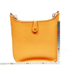 Yellow handbag with a ruler for scale on a white background