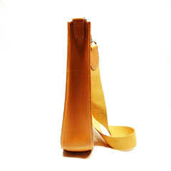 Yellow leather bag with strap on a white background