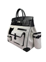 Black and white handbag with attached cup holder on a light gray background