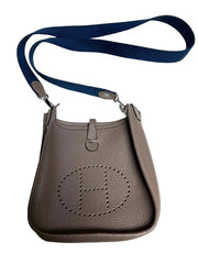 Gray handbag with a blue strap on a white background