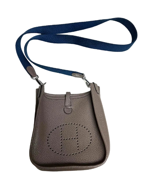 Brown handbag with a blue strap on a white background