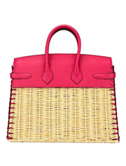 Pink handbag with wicker design on a white background