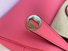 Close-up of a pink handbag with a gold buckle detail