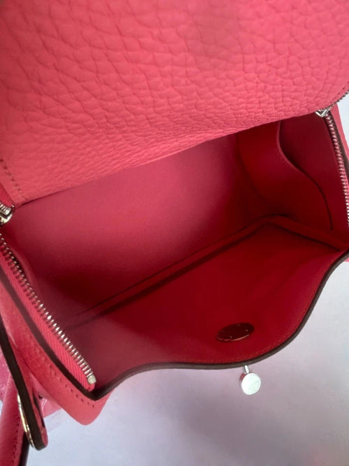 Close-up of a red textured handbag with a visible brand logo.