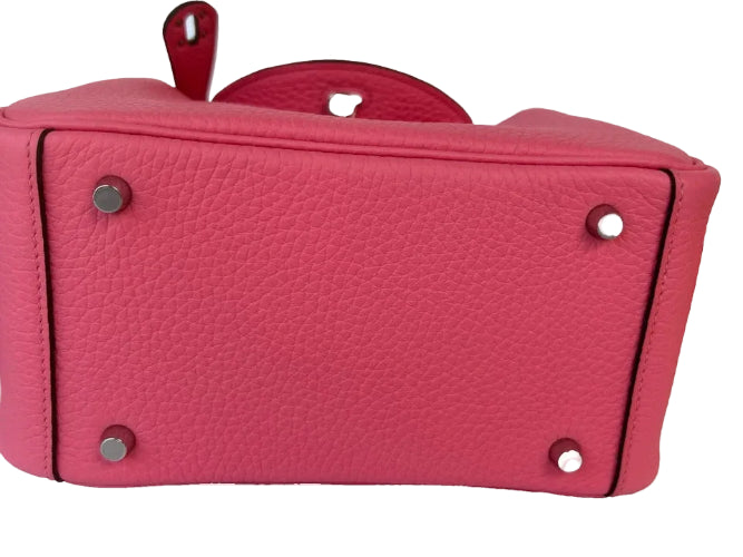 Close-up of a pink leather handbag with silver hardware on a white background