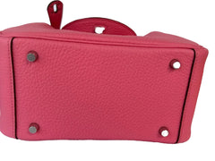 Close-up of a pink leather handbag with silver hardware on a white background