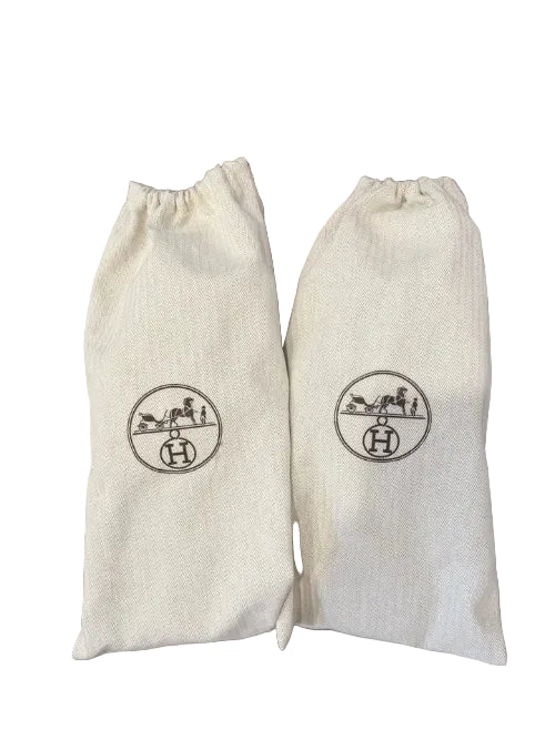 Two white drawstring bags with a logo on a wooden surface